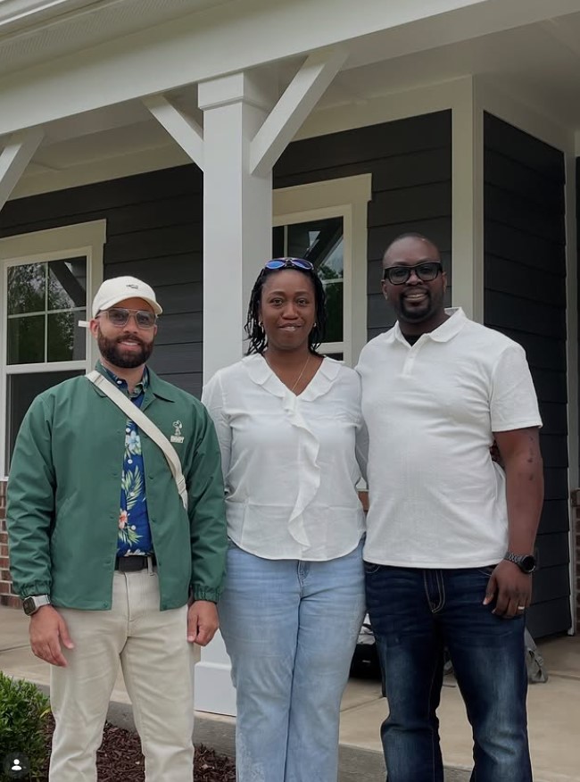 Brandon Lucas with new homeowners on their front porch